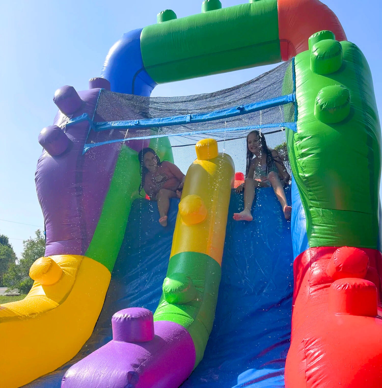 Girls playing on a Lego-inspired Brick Blitz water slide available from Rockin' Party Rentals in Simcoe, ON